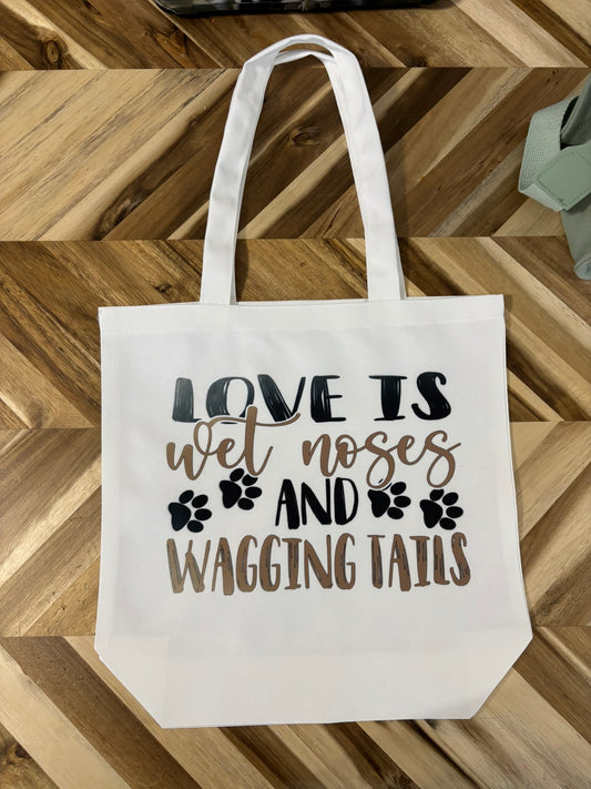 Love is wet noses and wagging tails tote bag
